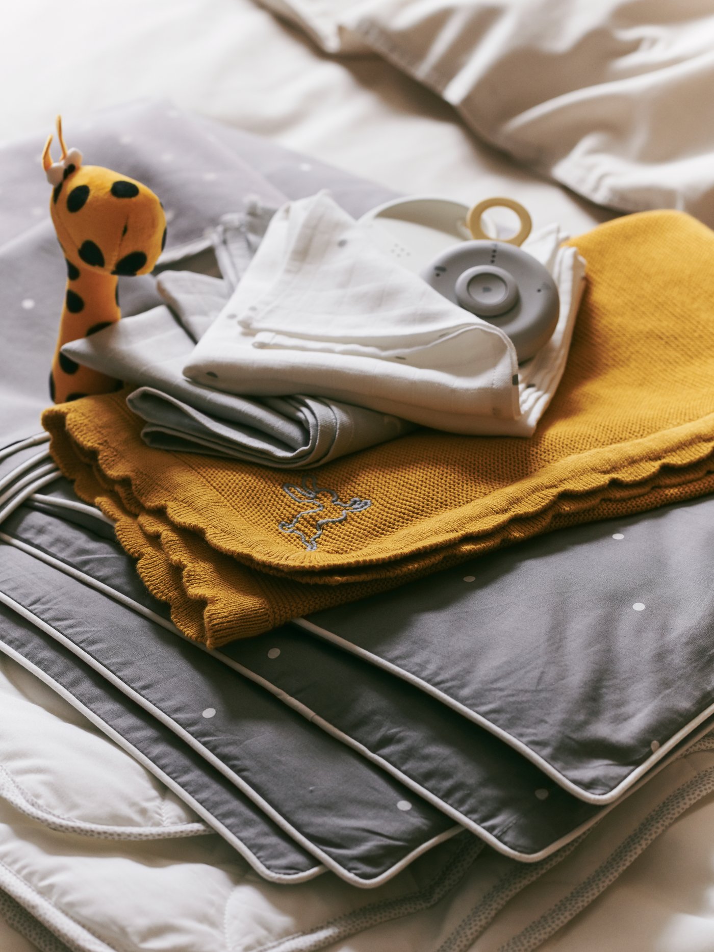 An assortment of baby textiles in 100% cotton, including SOLGUL blanket and LEN muslin squares.