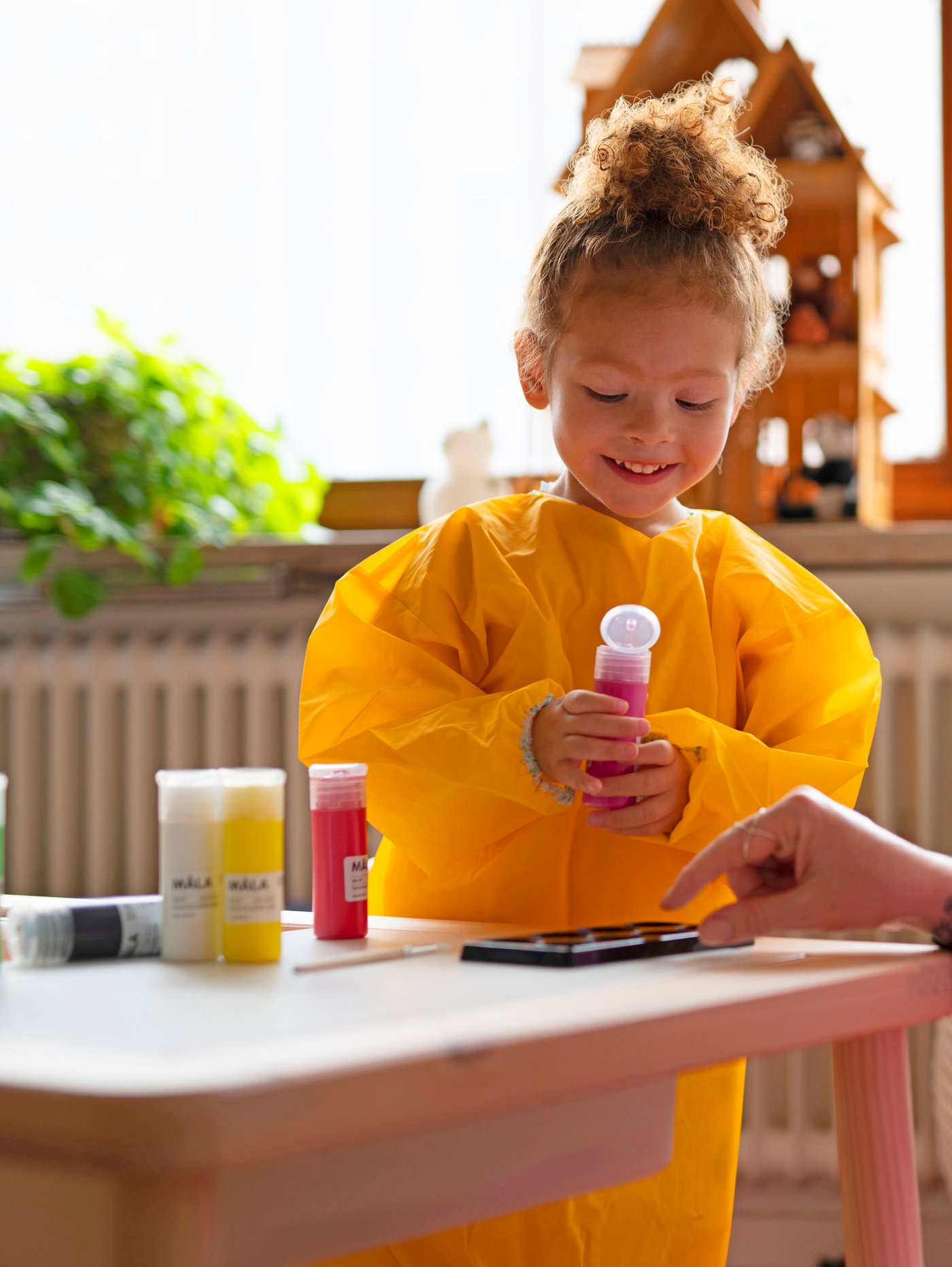 A woman and a child prepare MÅLA paint in a VARDAGEN muffin tin.