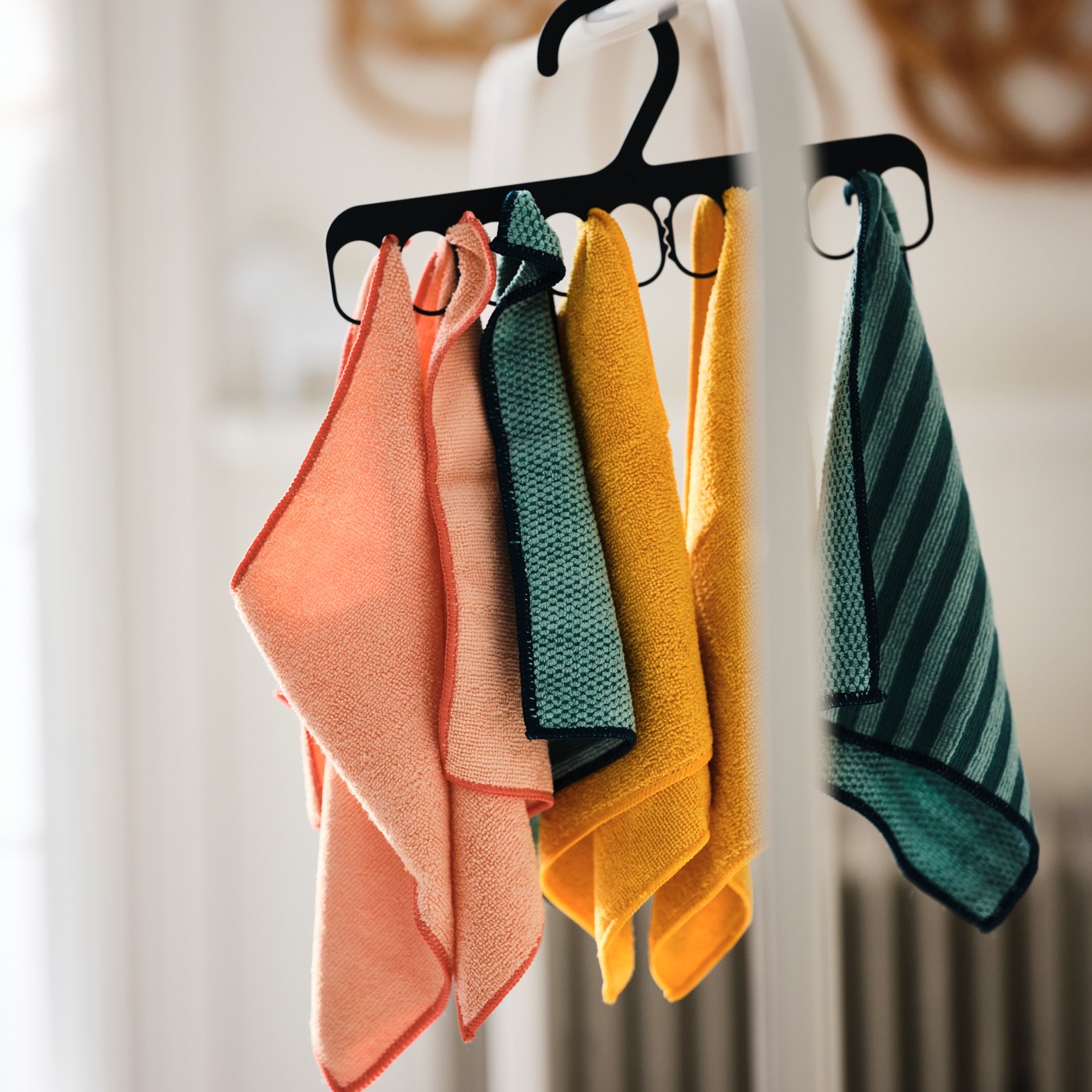 Plusieurs chiffons en microfibres PEPPRIG accrochés à un cintre avec 8 pinces SLIBB, lui-même suspendu à un portant MULIG.