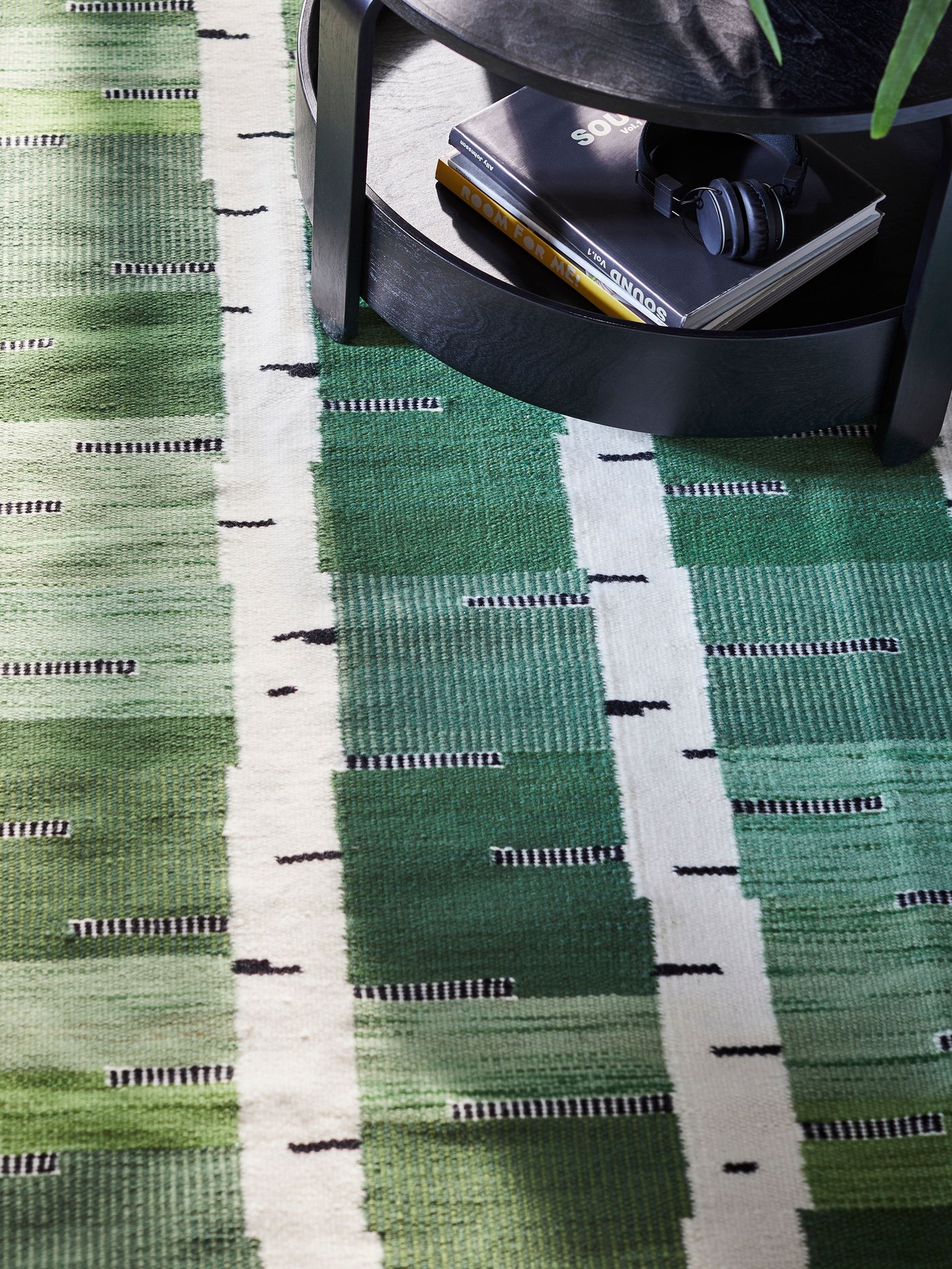 A green/white/black handwoven STOCKHOLM 2025 rug, flatwoven