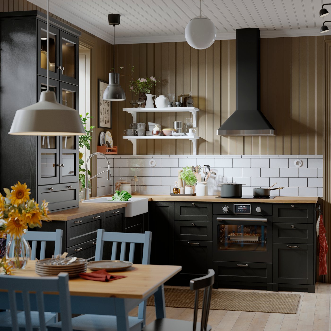 A kitchen with a black STENABY true fan oven is positioned beneath a sleek extractor hood, surrounded by cabinets and a sink.