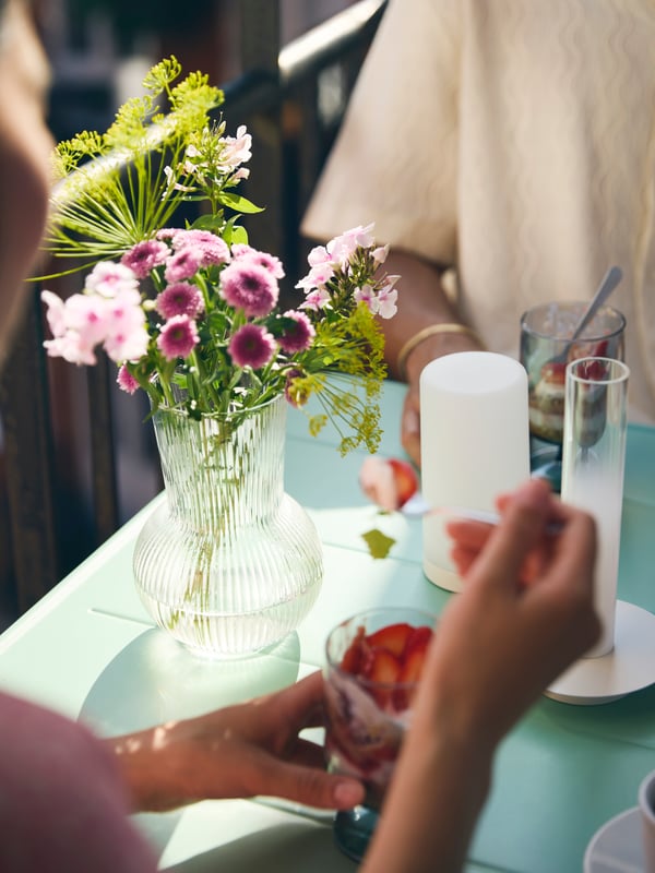 Couple sitting at SUNDSÖ table enjoing desserts.