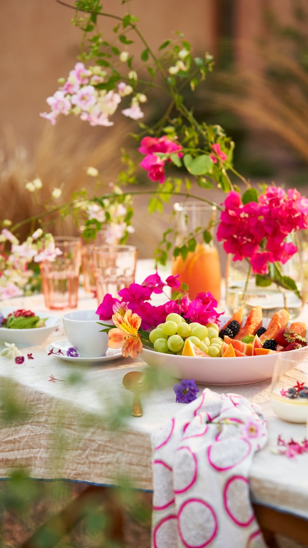Et bord er dækket med blomster og service. 