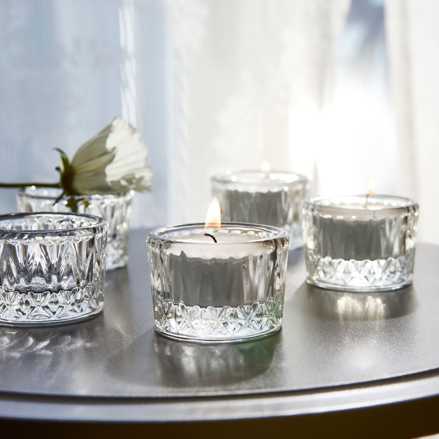 A clear glass/patterned SMÄLLSPIREA tealight holder