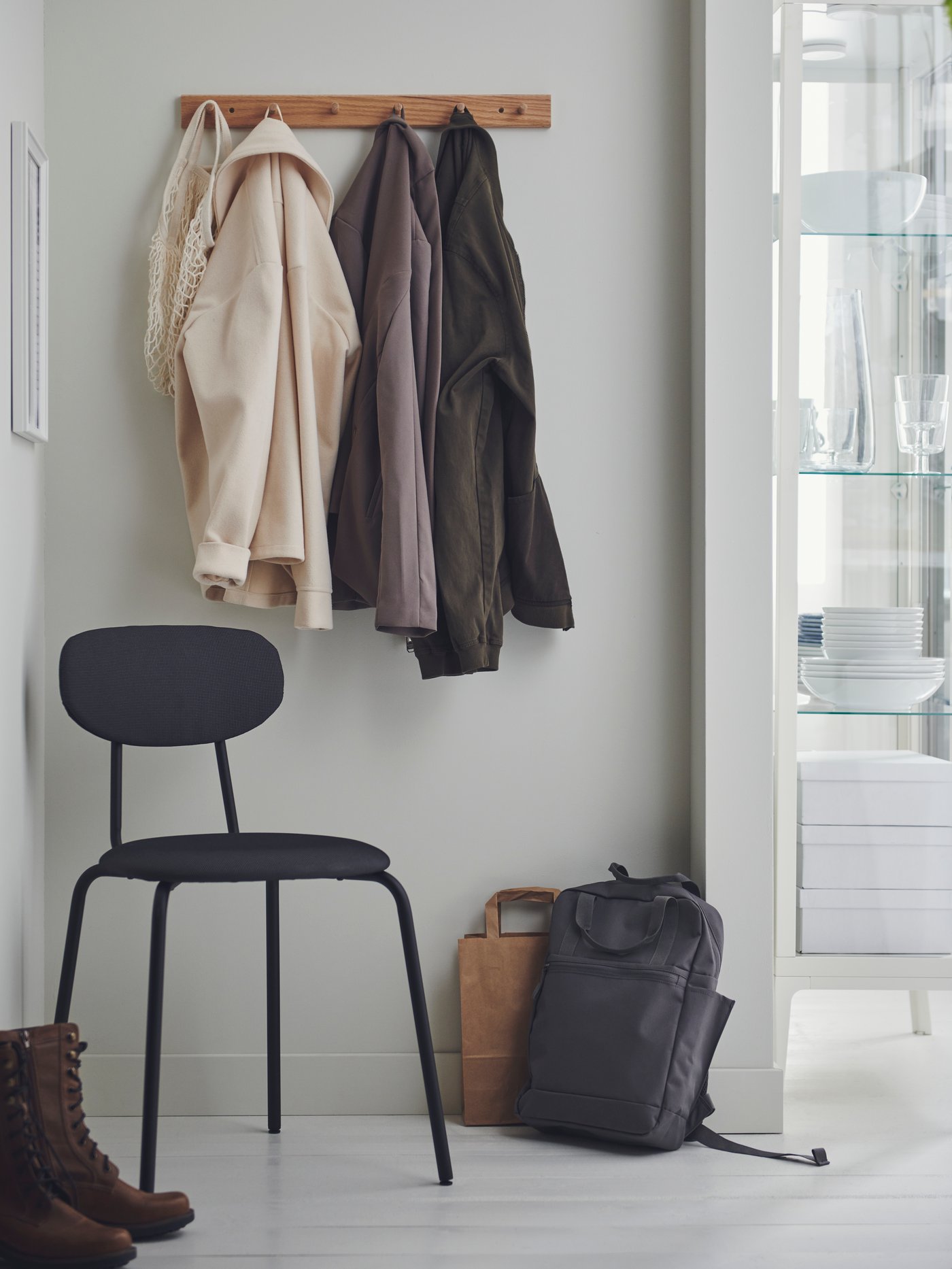 Patère murale en bois où sont suspendues des vestes.