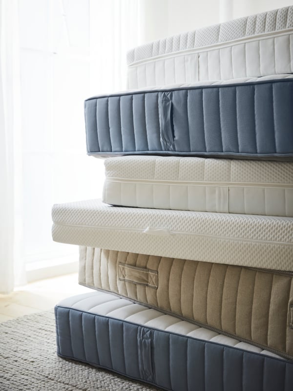 Empilement de matelas VATNESTRÖM, VALEVÅG, VÅGSTRANDA et autres en bleu clair, blanc et écru.