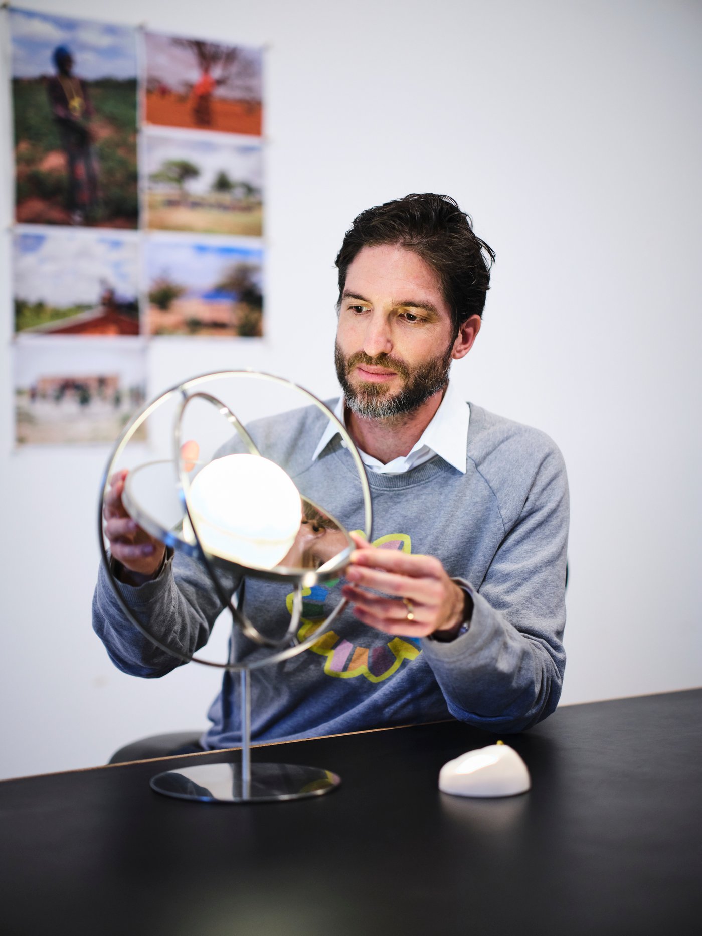 Felix Hallwachs daripada Little Sun sedang duduk di meja dengan pencahayaan berkuasa solar LED SAMMANLÄNKAD dan lampu meja.
