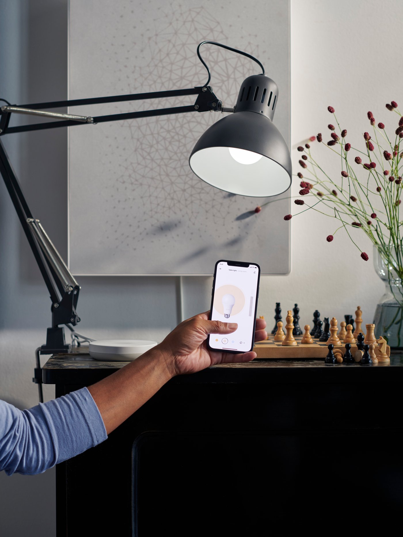 Une ampoule à DEL intelligente TRÅDFRI E27 avec gradateur, lumière blanche/coloré et 806 lumens dans un bureau à domicile