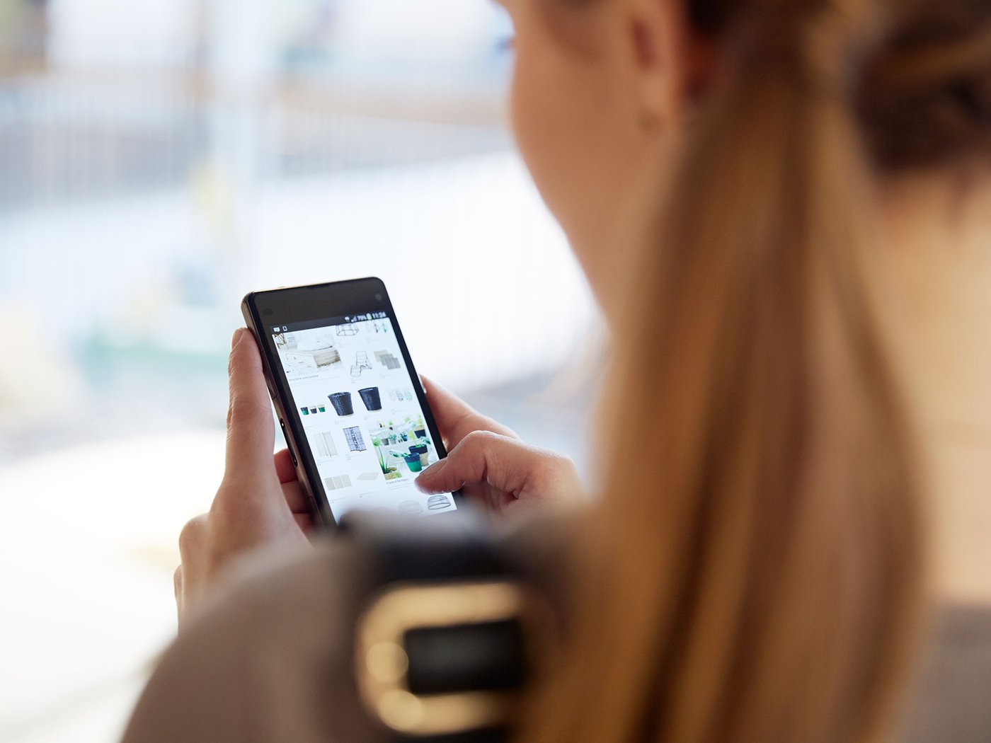 A woman looking the IKEA website on her mobile phone