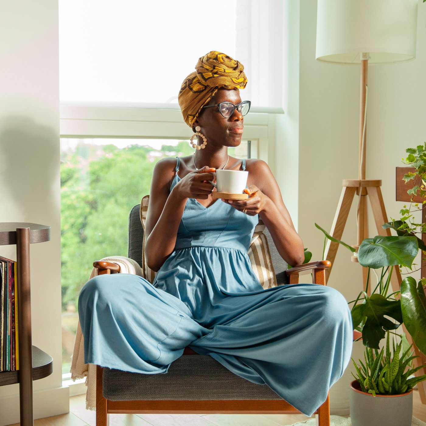 A relaxed woman sits in an armchair, sipping tea from an IKEA 365+ mug.