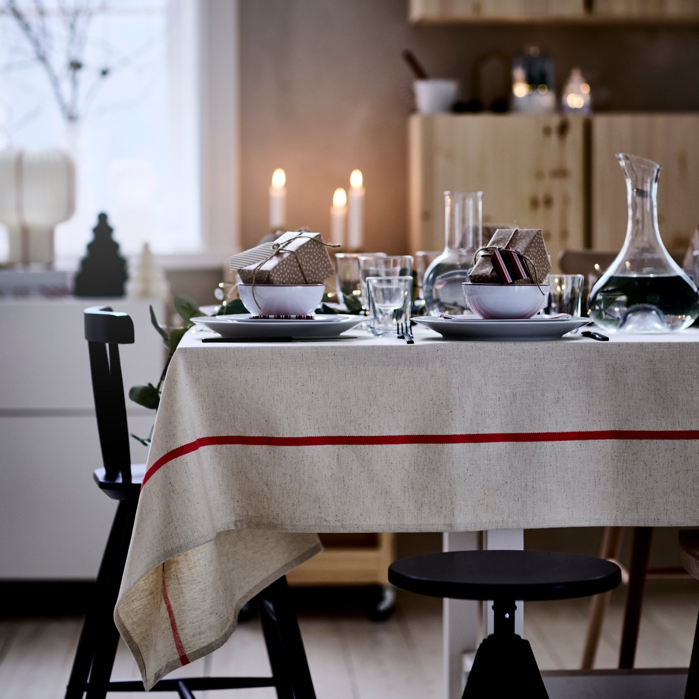 Ein gedeckter Tisch mit einer VINTERFINT Tischdecke in elfenbeinweiß/rot