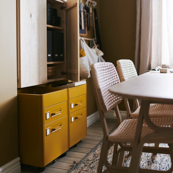 A handmade natural/dark blue MELHOLT rug, flatwoven in the dining room