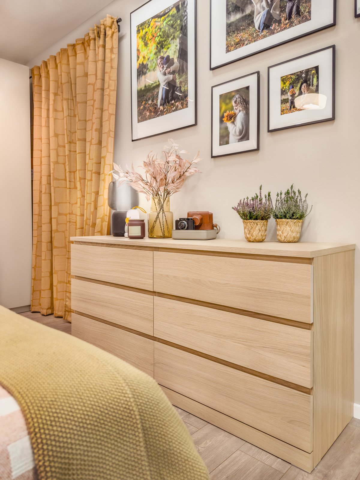Un dormitorio y frente a la cama una cómoda MALM de 6 cajones y sobre ella decoraciones y cuadros.