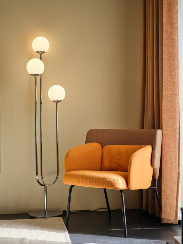 A chrome-plated/opal white glass SIMRISHAMN floor lamp in the living room