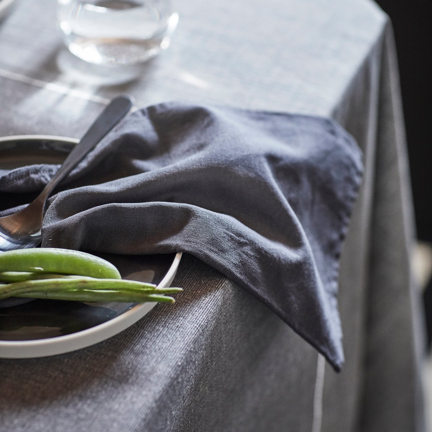 A dark grey SVARTSENAP napkin