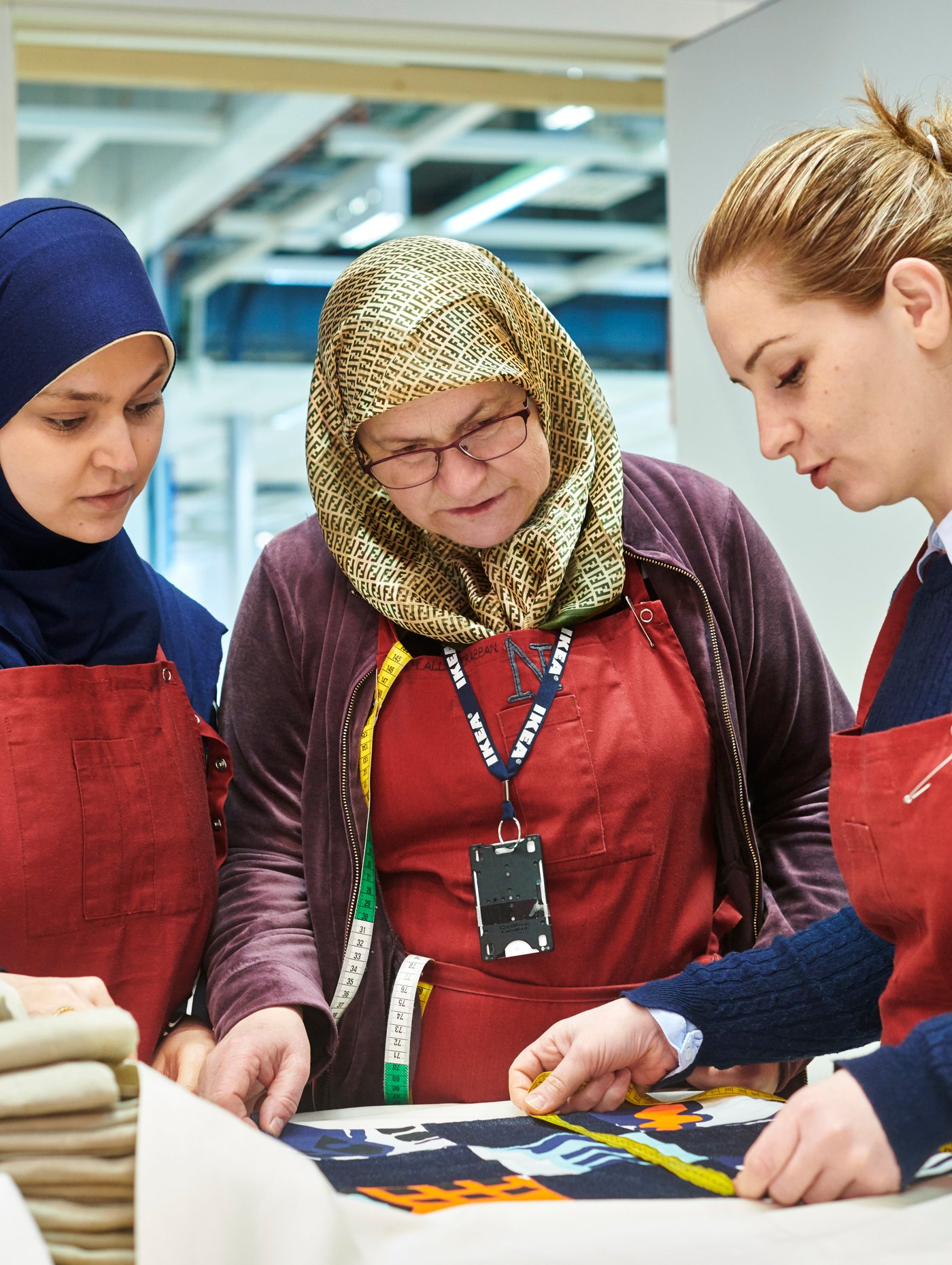 Dvoje zaposlenih iz studija za šivenje Yalla Trappan u robnoj kući IKEA u Malmeu, u Švedskoj, mere tkaninu.