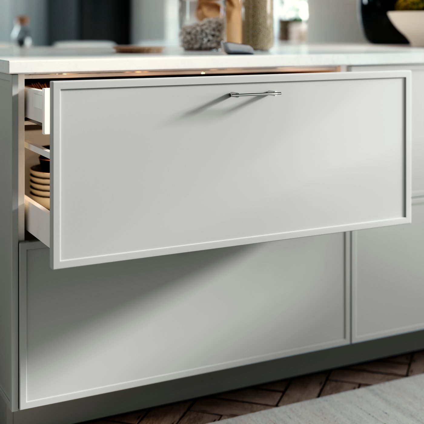 METOD kitchen drawer with an ASPUDDEN drawers front in light grey, opened slightly showing bowls inside.