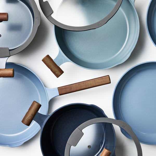 A set of KLIPPFISK frying pans and a sauté pan with wooden handles placed together.