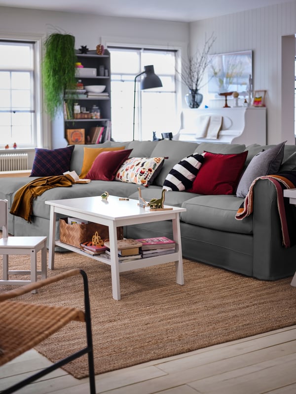 A large living room with a grey GRÖNLID four-seat sofa with chaise longues, a white LUNNARP coffee table standing next to it.