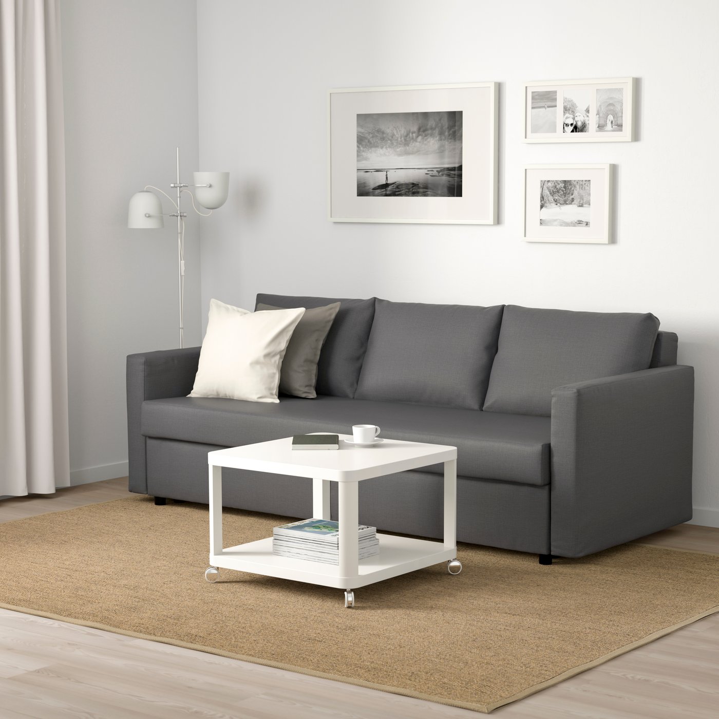 A Skiftebo dark grey FRIHETEN three-seat sofa-bed in the living room