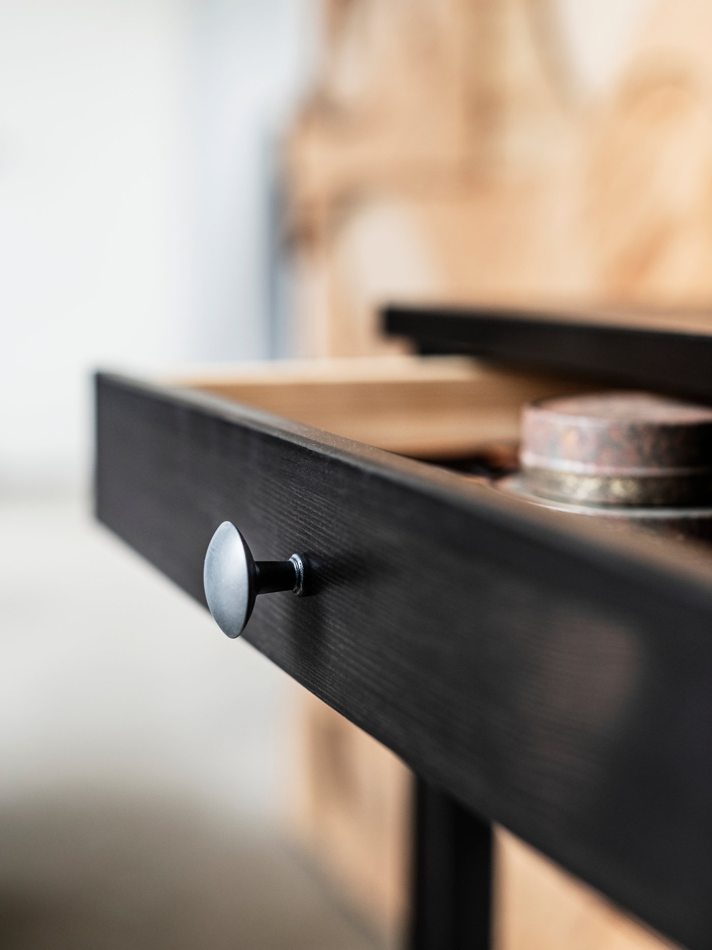 A black-brown HEMNES desk with two drawers, with one of the drawers open.