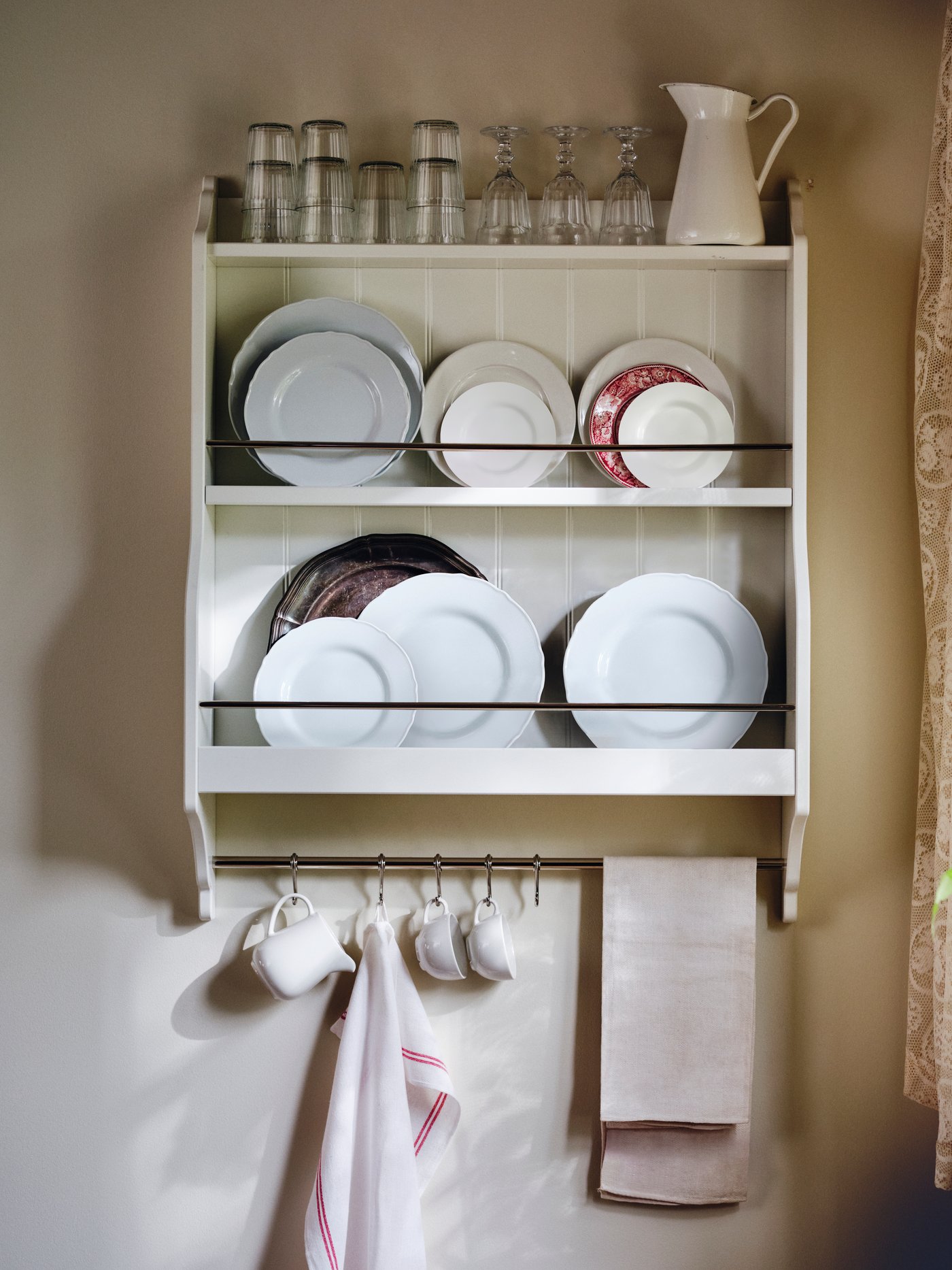 IKEA TORNVIKEN wall mounted plate shelf in off-white filled with plates and glassware