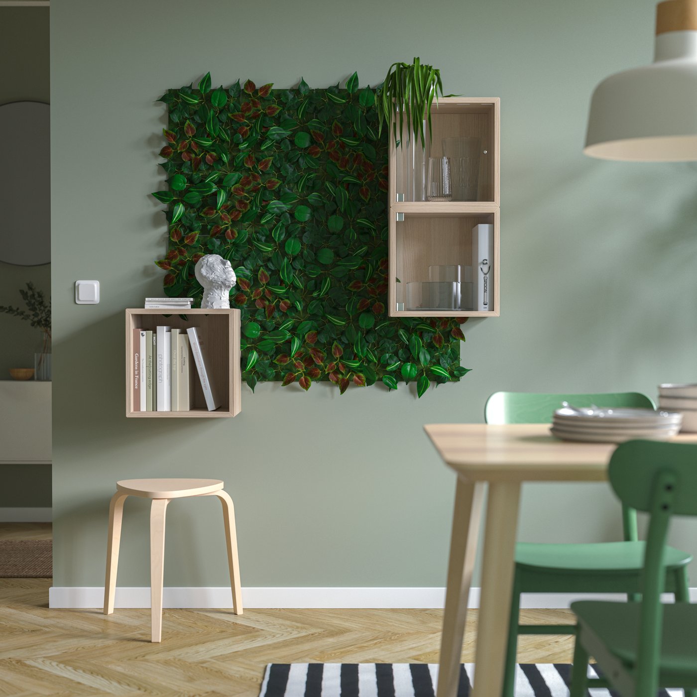 A bright room with a dining area, EKET cabinets and a square wall surface turned into a plant wall with leafy FEJKA plants.