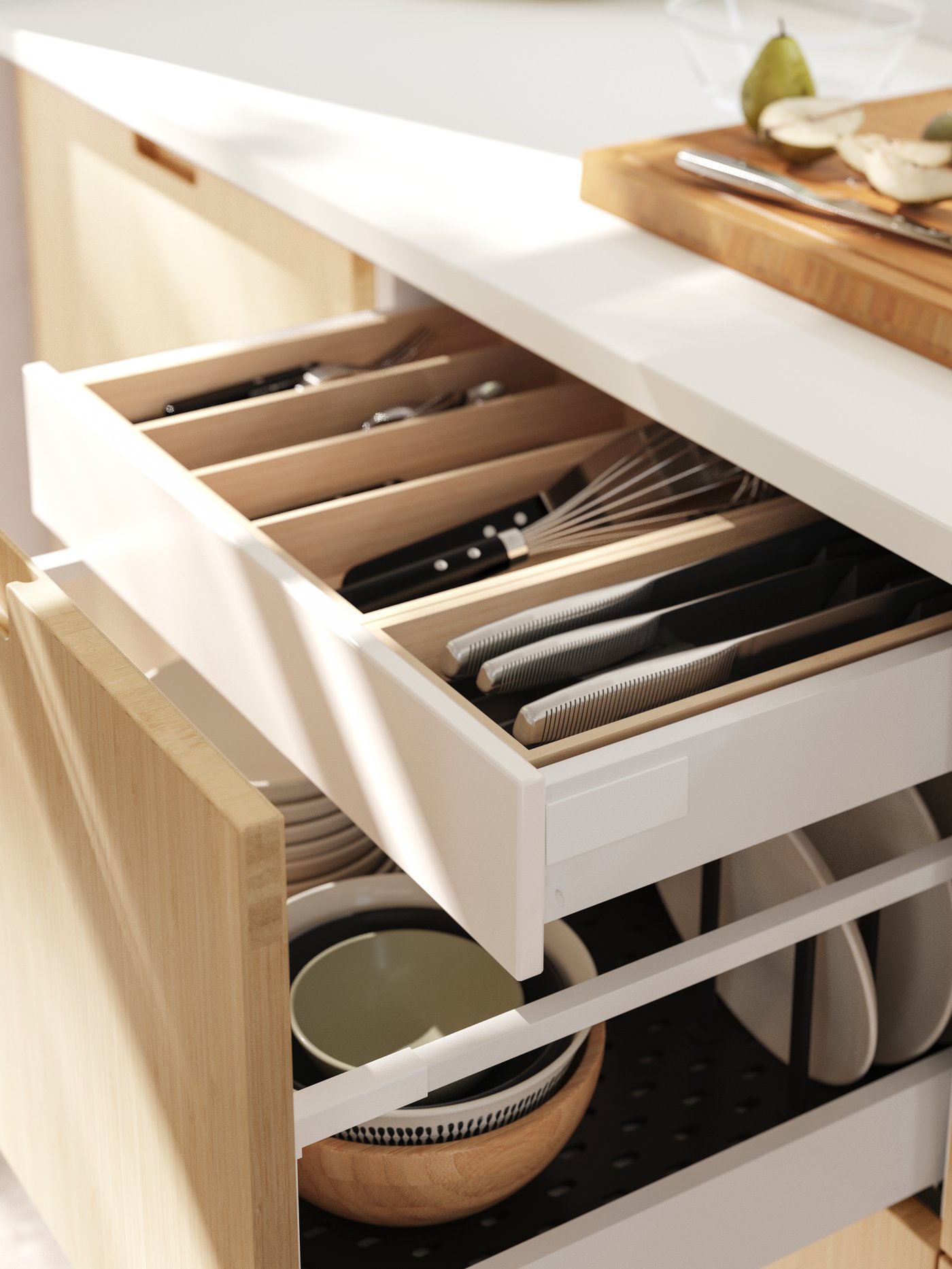 A kitchen drawer, with a FRÖJERED front, is open, revealing UPPDATERA drawer inserts with cutlery and three IKEA 365+ knives.