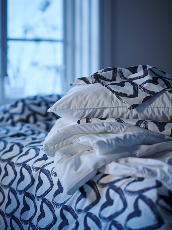 Una cama con ropa de cama de corazones y un plumón SÄFFEROT.
