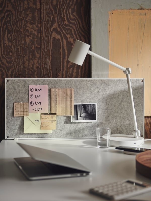 Notes and a photograph attached to a white TROTTEN noticeboard, which in turn is fastened to a white TROTTEN desk.