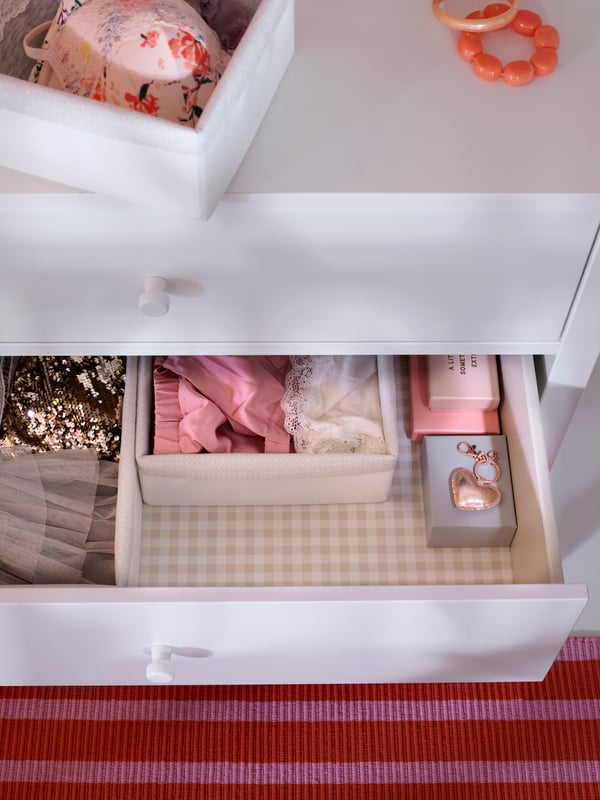 Close-up of GULLABERG chest of drawers, taken from above, with one drawer pulled out showing the neat order inside.