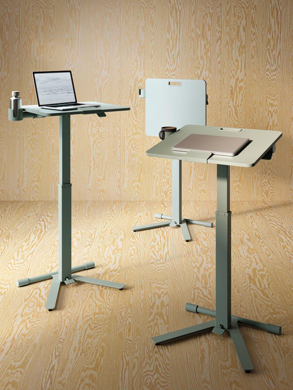 Three MITTZON laptop tables with castors in a space with wooden walls and floors. There are laptops on two of the tables.
