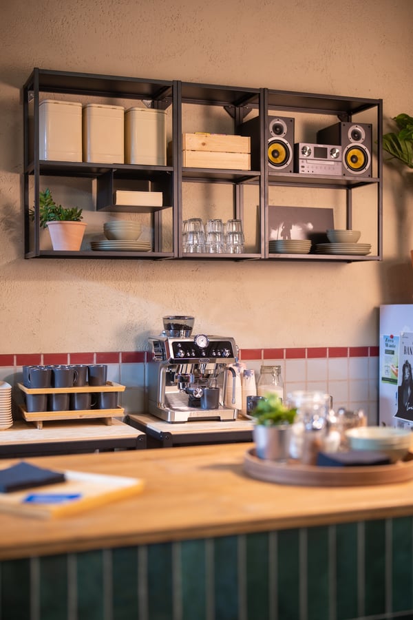 Een keukenwerkblad met ENHET opbergmodules en open planken, gecombineerd met servies, een koffiemachine en KORKEN potten, vormt een stijlvolle en functionele koffieruimte.