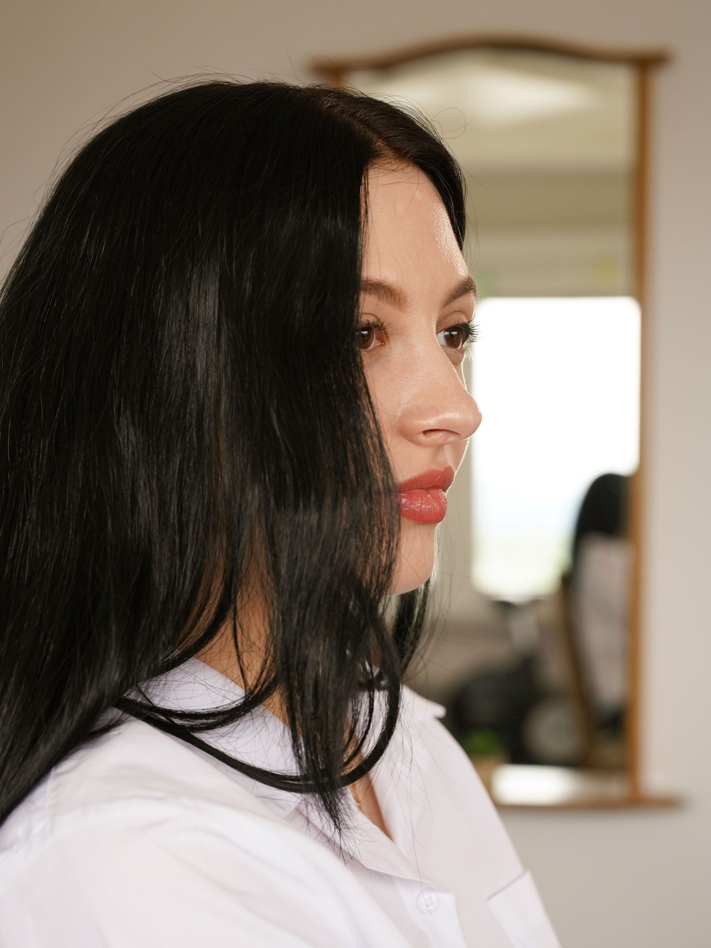 Jeune fille debout de profil dans une entrée.
