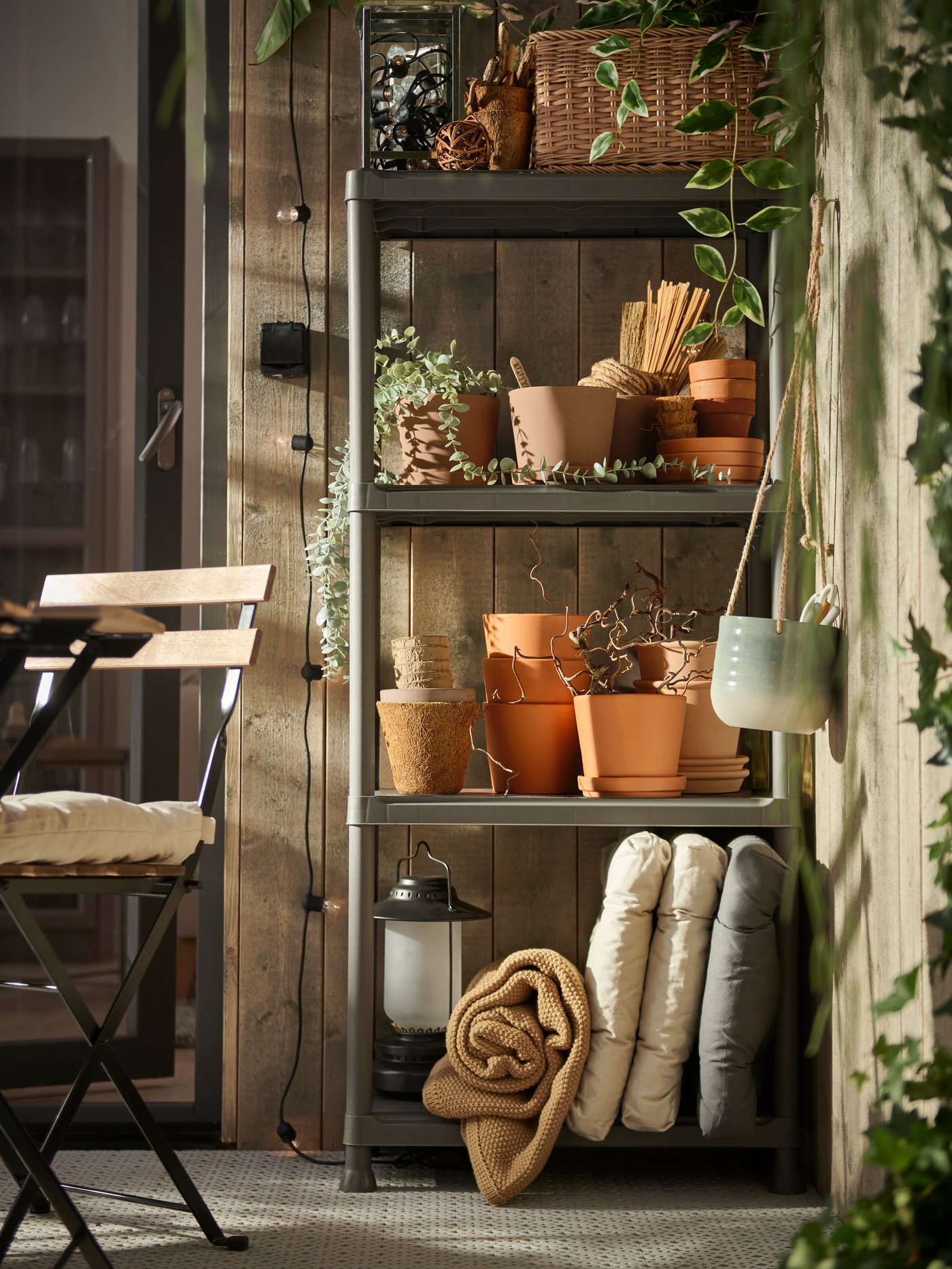 RUNMARÖ outdoor storage shelf in balcony area next to TARNO outdoor chair and dining table.
