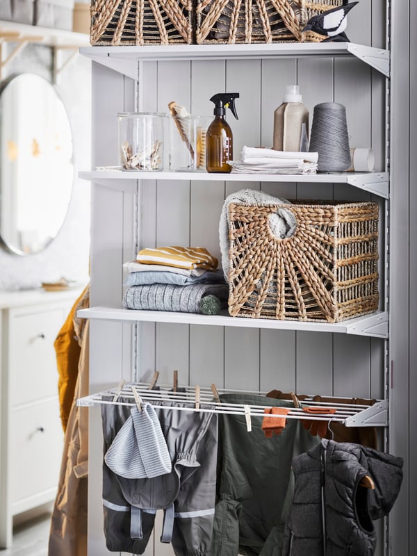 A shelf hung against a white wall with various accessories for the home.
