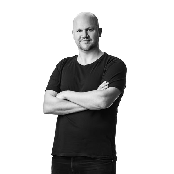 Crno-beli portret na kom se nalazi Daniel Yngvesson, dizajner odeljenja IKEA Food, u tamnoj majici kratkih rukava i farmerkama, u belom studiju.