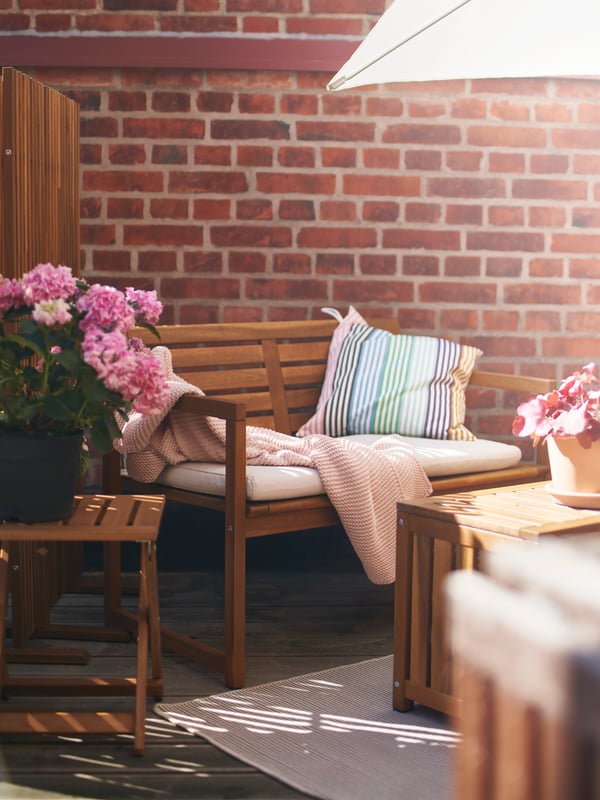 A light brown stained NÄMMARÖ bench with backrest, outdoor