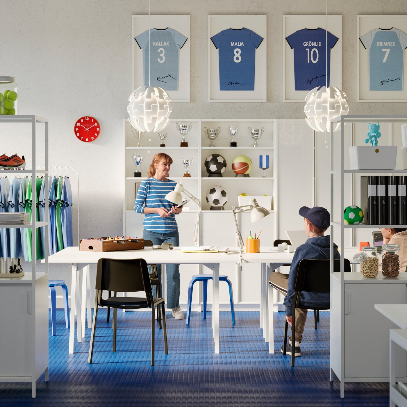 A large office with white TROTTEN tables and open storage shelves, black chairs and blue stools. Two people talking.