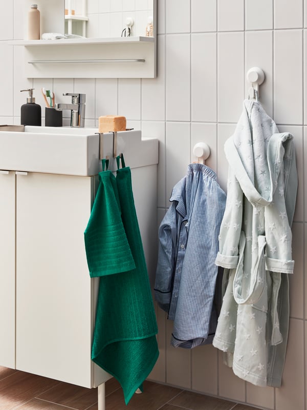 Wall section with two TISKEN hooks with suction cup of which two hold towels, while on the sink itself LILLÅNGEN hanger.