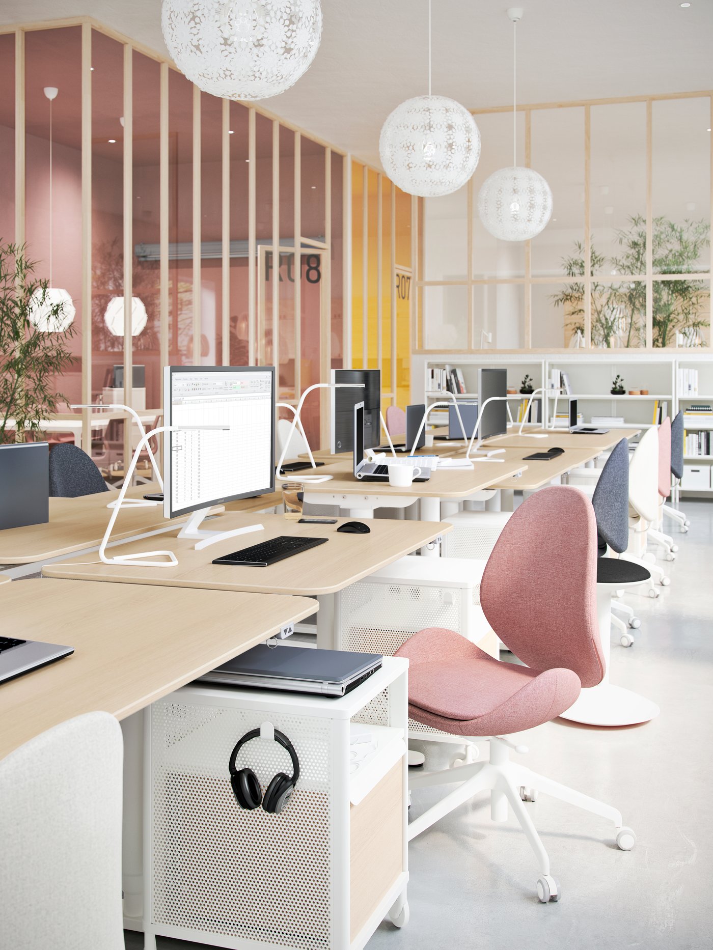 A workspace with lots of desks, swivel chairs and computer screens, storage and hanging lighting.
