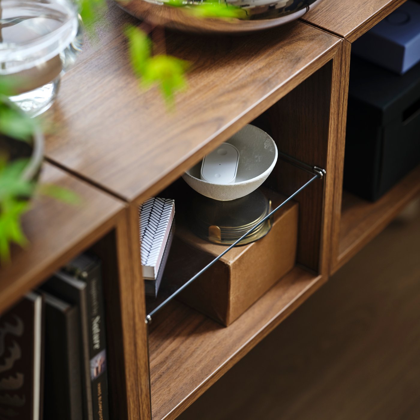 EKET insert fitted inside an EKET cabinet, with bowls, books and decorative objects stored on the shelves.
