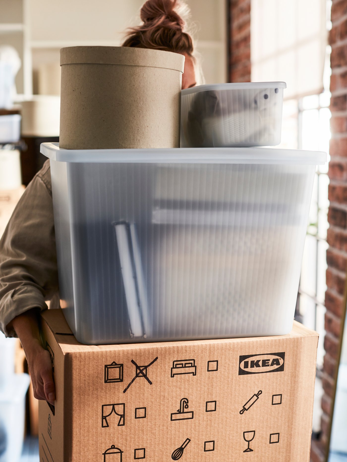 IKEA RYKTA transparent textured box with lid being carried by a person.