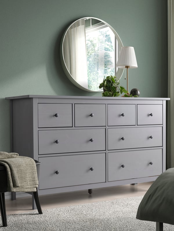 a white table lamp above a dresser