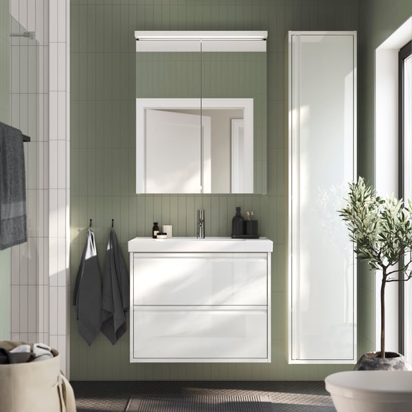A high-gloss white ÄNGSJÖN high cabinet with door in the bathroom