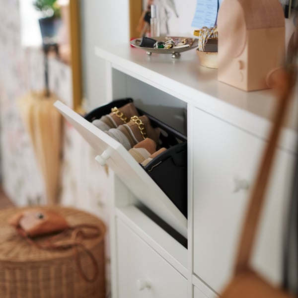 A white GULLABERG shoe cabinet with the top compartment open showing two pairs of shoes. Keys and a speaker are on top.