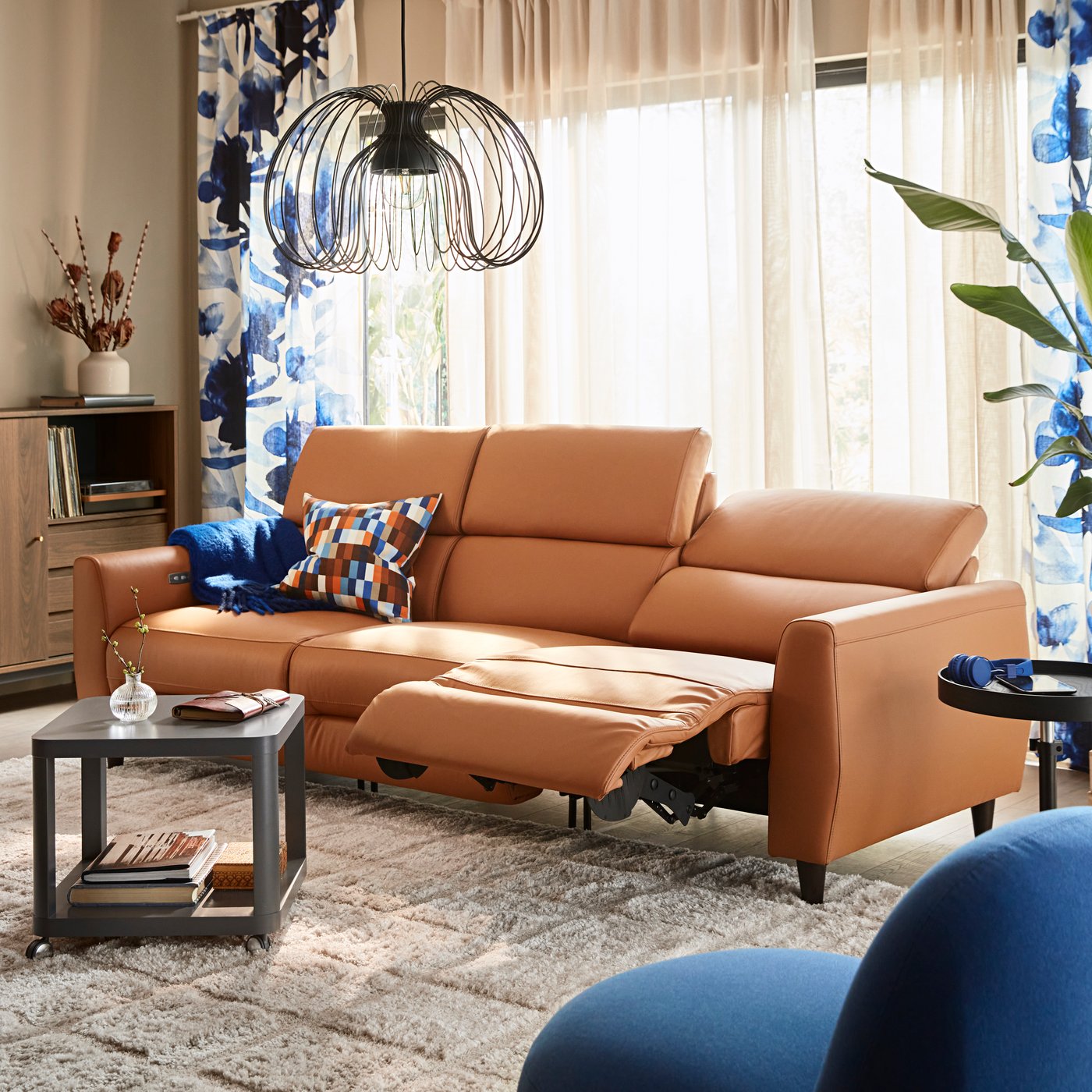 A Grann/Bomstad golden-brown RULLERUM 3-seat sofa w 2 electric recliners in the living room