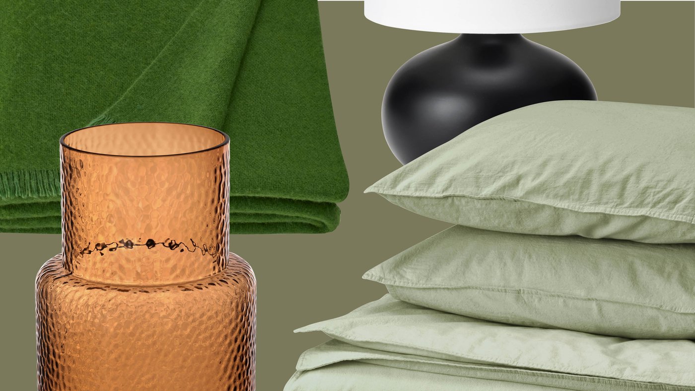 Un plaid vert, un vase en verre texturé ambré, un pied de lampe noir avec un abat-jour blanc et une literie IKEA vert pâle créent une ambiance intérieure chaleureuse et harmonieuse.