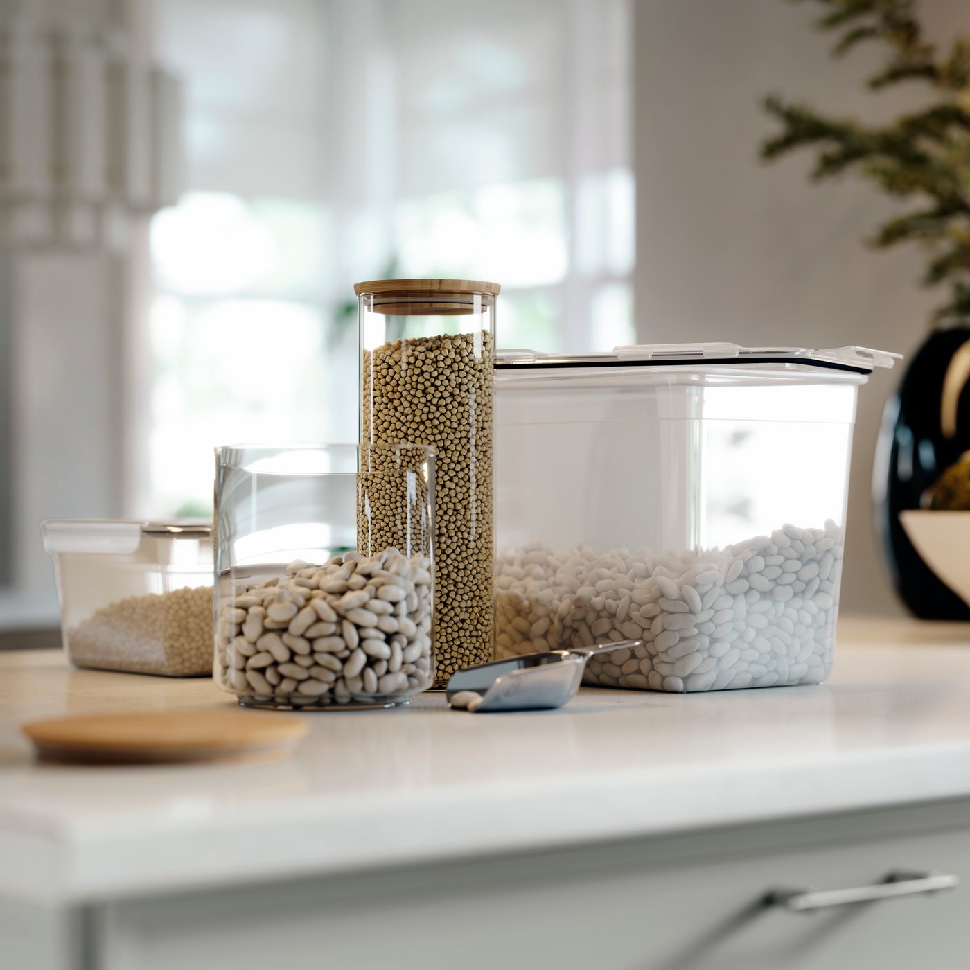 EKLATANT jar with lid filled with beans on a kitchen worktop, placed next to more clear food storage containers.