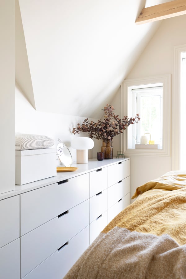 Eine dunkelgelb-cremefarbene UGGLEFLY-Decke im Schlafzimmer
